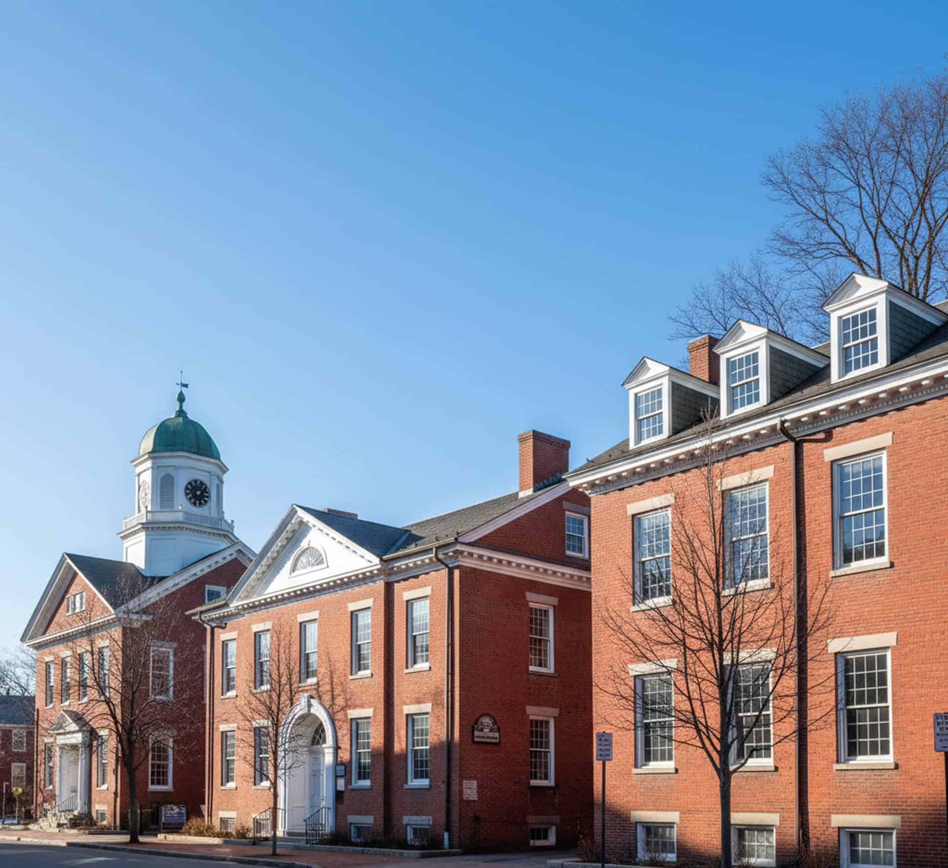 Historic brick buildings with a green dome clock tower, representing Cornerstone Dental Group in Westford, MA, emphasizing quality dental care and patient comfort.