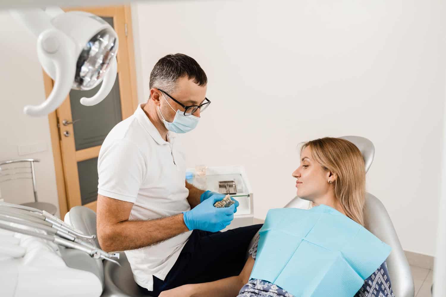 Dentist examining a patient during a cosmetic dental consultation for veneers.