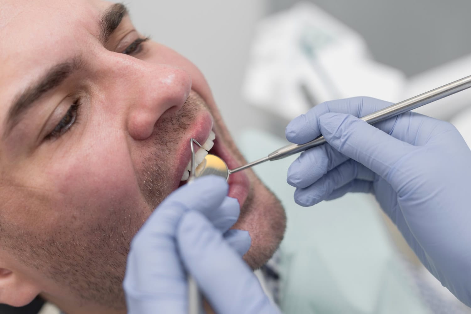 Dentist examining a patient’s tooth with dental instruments during a dental crown evaluation and oral health checkup.
