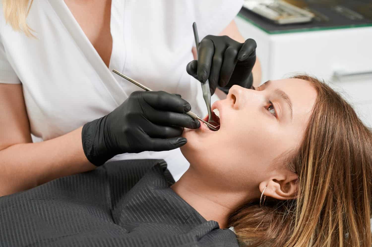 Dentist examining a patient’s teeth during a routine dental examination and consultation.