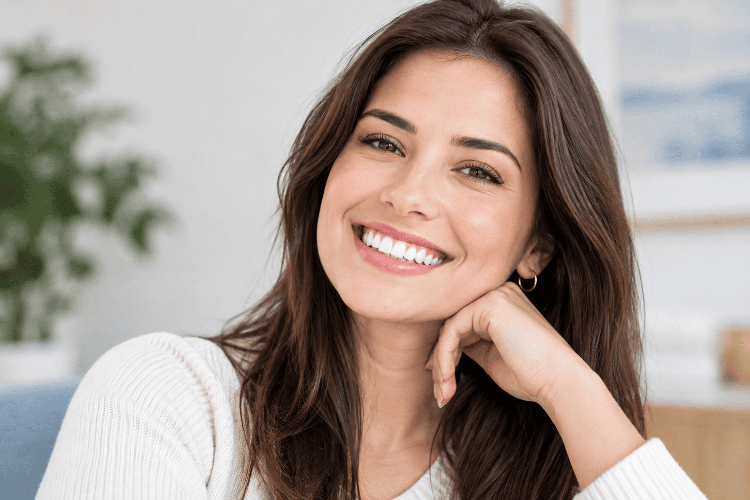 Confident woman smiling with natural-looking teeth after cosmetic dental treatment for improved smile appearance.
