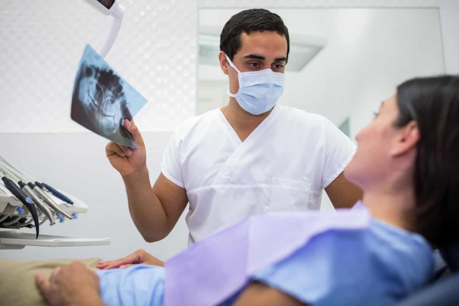 Dentist showing a patient a dental X-ray during an AI dental diagnostics visit for oral health assessment in Westford.